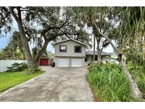Charming two-story home with a two-car garage and mature landscaping creating a welcoming curb appeal at 945 College Hill Dr, Clearwater, FL 33765