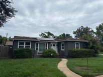 Charming single-story home featuring a well-manicured lawn and solar panels at 1601 14Th N St, St Petersburg, FL 33704