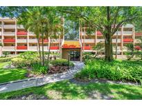 Attractive condo complex with well-maintained landscaping and trees leading to the entrance at 3062 Eastland Blvd # 311, Clearwater, FL 33761
