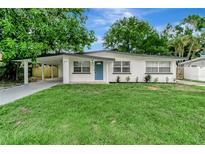 Charming single-story home featuring a carport, light blue door, and a lush front lawn at 517 Fairhope Dr, Apollo Beach, FL 33572