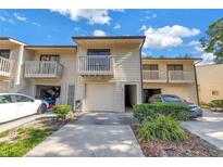 Beige townhome featuring a balcony, garage and well-maintained landscaping, creating an inviting curb appeal at 6236 93Rd N Ter # 3502, Pinellas Park, FL 33782