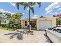 Charming single story home with a brick driveway, lovely landscaping, and a one car garage at 751 Bayshore Dr, Tarpon Springs, FL 34689