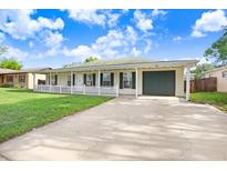 Charming single story home with a well-manicured lawn, picket fence, and a one car garage at 7841 Royal Stewart Dr, New Port Richey, FL 34653