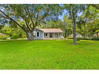 Charming home with a metal roof, covered porch, and lush green lawn at 8600 Shenandoah Run, Wesley Chapel, FL 33544