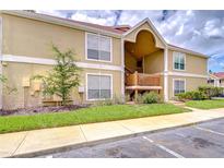Inviting condo exterior with wood accents and manicured lawn under a bright, cloudy sky at 9481 Highland Oak Dr # 1506, Tampa, FL 33647