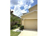 Inviting home featuring a manicured lawn and a two-car garage, perfect for comfortable suburban living at 11309 Villas On The Green Dr, Riverview, FL 33579