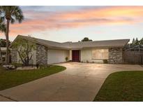 Charming single-Gathering home with stone accents, mature landscaping, and a spacious driveway at 13986 Bonnie Brae Dr, Largo, FL 33774