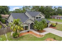 Charming two-story home with well-maintained landscaping, stone facade, black shingle roof, and a two car garage at 15846 Glenarn Dr, Tampa, FL 33618