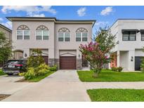 Charming townhome with a well-manicured lawn, complemented by a crape myrtle and a stone-accented garage at 2405 W North B St # 1, Tampa, FL 33609
