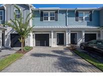 Charming townhome featuring a well-maintained front yard, paved driveway, and attached garage at 2919 Grand Kemerton Pl, Tampa, FL 33618