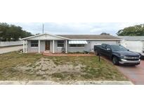Charming single-story home with a well-maintained lawn and a paved driveway in front at 3243 Umber Rd, Holiday, FL 34691
