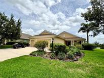 Charming single-story home featuring a well-manicured front lawn and a two-car garage at 16413 Rivers Reach Blvd, Parrish, FL 34219