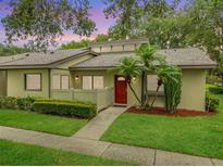 Charming single-story home with vibrant landscaping and a welcoming red front door at 200 Gretchen Ct, Oldsmar, FL 34677