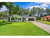 Charming single-story home features a well-manicured lawn and a stone-accented facade at 210 Lake Hobbs Rd, Lutz, FL 33548