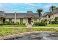 Charming townhouse featuring a unique roofline, complemented by lush landscaping and inviting curb appeal at 2206 Cordova Grn # 2206, Seminole, FL 33777