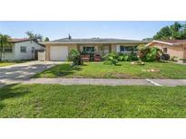 Charming single-story home featuring a well-manicured lawn and lush landscaping at 2518 Keen Park Dr, Largo, FL 33771