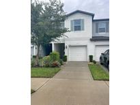 Charming townhome featuring a one-car garage, lovely landscaping, and light-colored exterior at 3926 Cat Mint St, Tampa, FL 33619
