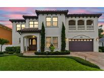 Elegant two-story home with a barrel tile roof, manicured lawn, and an attached two-car garage at 4012 W Obispo St, Tampa, FL 33629