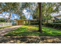 Charming bungalow with lush landscaping, a well-manicured lawn, and a driveway leading to an attached single-car garage at 5135 21St Avenue N, St Petersburg, FL 33710