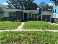 Charming single-story home featuring a brick facade, lush front lawn, and an attached single car garage at 641 Geneva Pl, Tampa, FL 33606