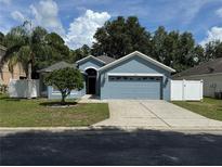 Charming single-story home with a well-manicured lawn and attached two-car garage at 12216 Southbridge Ter, Hudson, FL 34669