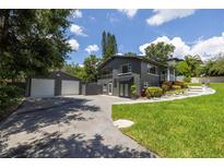 Two-story home boasts a well-kept lawn, a separate garage, and a driveway leading to the entrance at 1600 Lonesome Pine Ln, Tarpon Springs, FL 34689