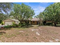Charming single-story home with a stone accent wall and mature trees, offering privacy and curb appeal at 17207 Bosley Dr, Spring Hill, FL 34610