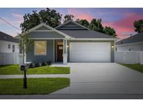 Charming one-story home with a well-manicured lawn, a two-car garage and appealing landscaping at 1803 E Powhatan Ave, Tampa, FL 33610
