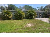 Quaint single-story home featuring mature landscaping in the front yard at 3927 Huntington Ne St, St Petersburg, FL 33703