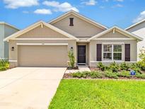 Charming single-Gathering home with a manicured lawn, two-car garage, and neutral color palette at 5474 Flint Hills Dr, Wimauma, FL 33598