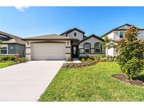 Charming single-Gathering home with a well-manicured lawn, landscaping, and a two-car garage at 8077 Tea Olive Ter, Palmetto, FL 34221
