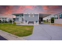 Charming home featuring a covered parking area, bench seating, and well-manicured lawn at 108 W Saint Johns Way # 210, Apollo Beach, FL 33572