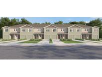 A row of townhouses, showcasing individual garages, neutral color palette, and manicured lawns at 17261 English Chestnut Way, Land O Lakes, FL 34638