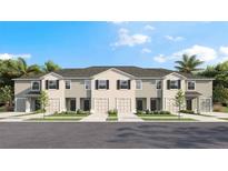 Charming townhome featuring a neutral color scheme, attached garages, and professionally landscaped front yard at 17473 Spanish Oak Loop, Land O Lakes, FL 34638