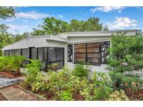 Charming home exterior with lush landscaping and unique window details at 209 Se Jefferson N Cir, St Petersburg, FL 33702