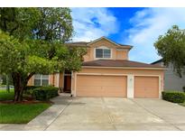 Charming two-story home with a three car garage and lush landscaping at 5154 Balsam Dr, Land O Lakes, FL 34639