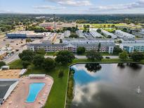 Aerial view of community featuring a large pool, lake with fountain, and several multi-story buildings at 6015 19Th N St # 117, St Petersburg, FL 33714