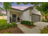 Charming home featuring a gray door with wreath, gray trim, and a two-car garage at 6218 Magnolia Park Blvd, Riverview, FL 33578