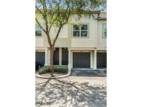 Inviting two-story townhome featuring an attached garage, neutral paint, and well-maintained landscaping at 1107 Normandy Trace Rd, Tampa, FL 33602