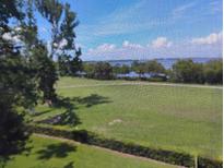 Scenic view of a green field with trees and a body of water in the distance at 2617 Cove Cay Dr # 306, Clearwater, FL 33760