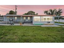 Charming home featuring a sunroom, open patio, and lush lawn near the waterfront, perfect for relaxation at 800 Chesapeake Dr # 23, Tarpon Springs, FL 34689