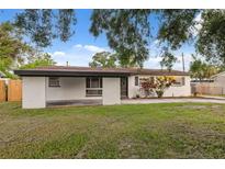 Charming one-story home with front yard, covered parking, and painted white brick exterior at 8256 Lark St, Seminole, FL 33777