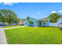 Charming single-story home with a bright blue exterior and lush green lawn at 12351 Cloverstone Dr, Tampa, FL 33624