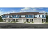 Modern townhome exterior featuring a blue and white facade, garage, and neatly maintained landscaping at 13240 Stable Pl, Parrish, FL 34219