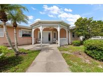 Charming home entrance featuring a decorative white portico, walkway, and a well-maintained lawn at 1453 Belleair Rd, Clearwater, FL 33756