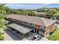 Two-story condo showcasing a covered parking area, and well-maintained lawn at 14625 Par Club Cir # 14625, Tampa, FL 33618