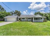 Charming single-story home with well-maintained lawn, attached garage and inviting front porch at 2612 Lenna Ave, Seffner, FL 33584