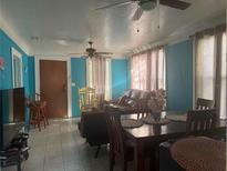 Cozy living room featuring tile floors, ceiling fans, dining table and furniture at 2905 W Chestnut St, Tampa, FL 33607