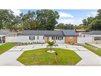 Charming single-story home with a well-manicured lawn and modern driveway at 3909 W Oklahoma Ave, Tampa, FL 33616