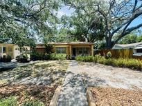 Charming single-story home featuring brickwork and mature trees in a well-maintained front yard at 5901 N 34Th St, Tampa, FL 33610